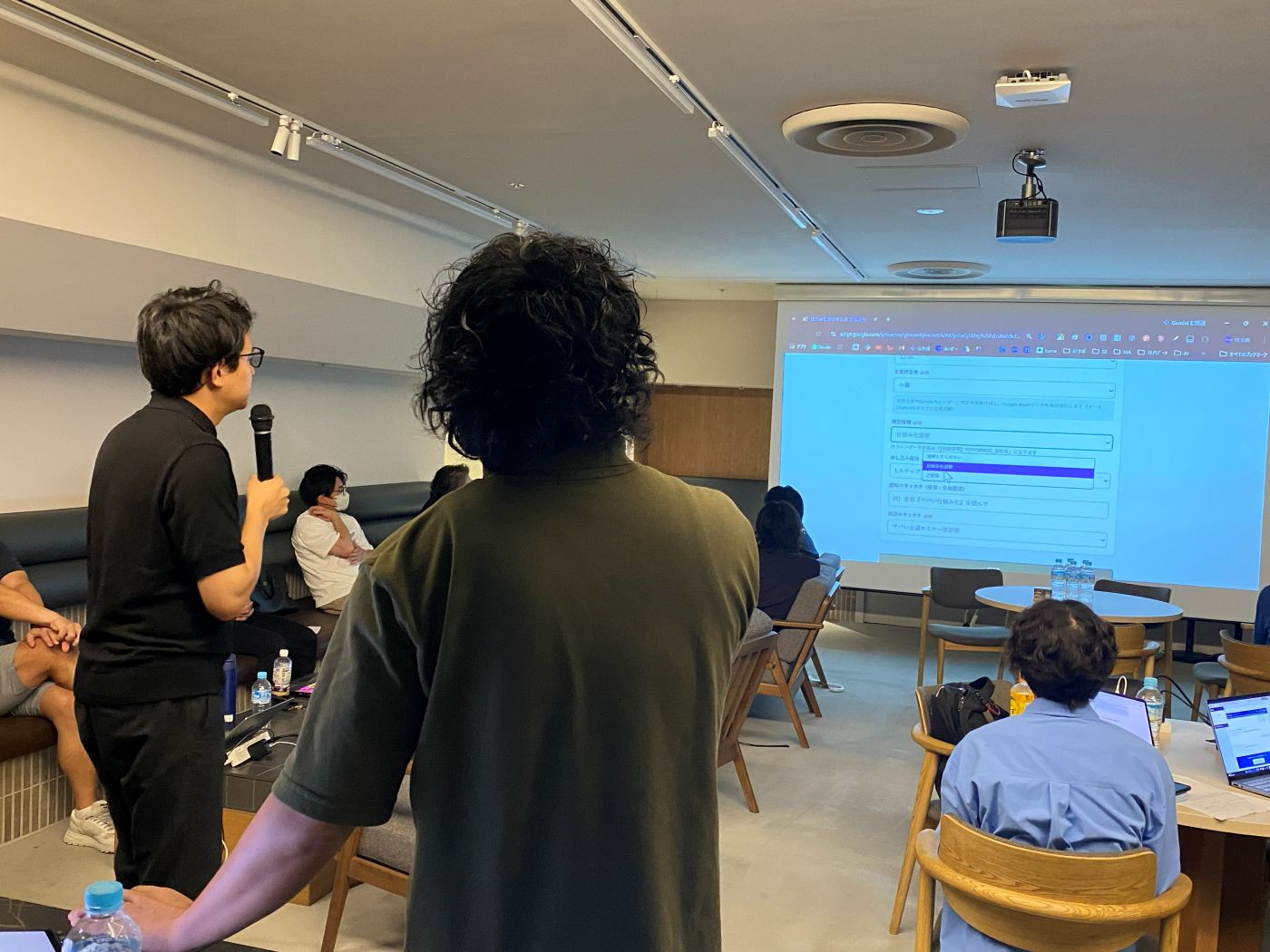 スクリーンの前で発表する様子